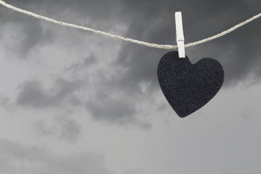 Yağmur bulutları ba kahverengi kenevir ipte asılı Black Heart kağıt