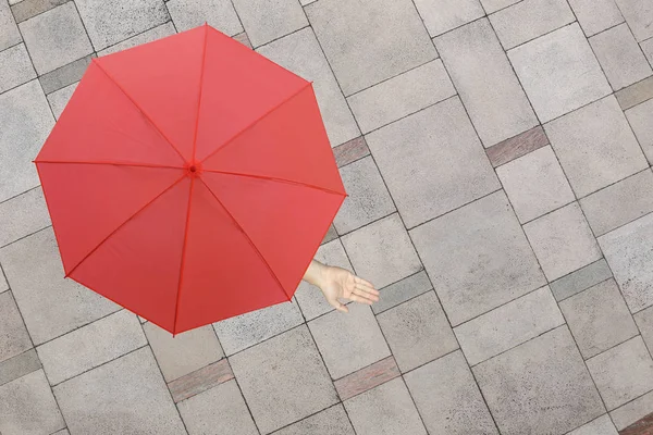 红伞和一只手的人站在石头地板和手上 — 图库照片