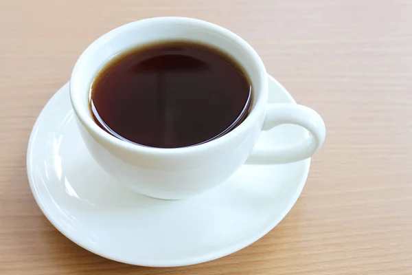Ζεστό καφέ σε ένα λευκό φλιτζάνι καφέ στο ξύλινο τραπέζι. — Φωτογραφία Αρχείου