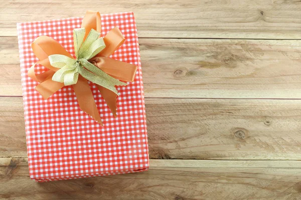 Red gift box on the wooden floor. — Stock Photo, Image