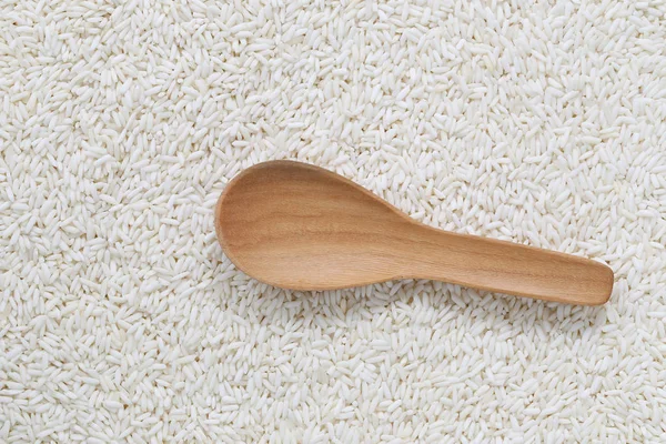 Cuchara de madera vacía sobre arroz blanco orgánico, arroz glutinoso o s —  Fotos de Stock