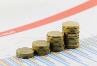 çubuk grafik kağıt iş belgeler üzerinde altın sikke.