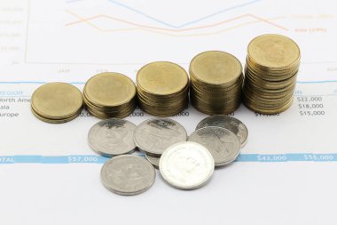 çubuk grafik kağıt iş belgeler üzerinde altın sikke.