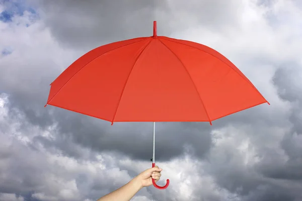 Parapluie rouge à la main et protection contre la pluie . — Photo