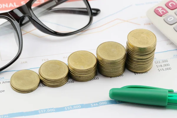 Gráfico de barras de monedas de oro en documentos comerciales de papel . — Foto de Stock