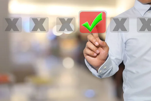 Палець бізнесмена торкається зеленої кнопки і білої галочки — стокове фото