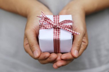 Kadınların elleri beyaz hediye kutusu.