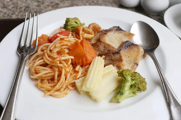 Spaghetti goreng dan ikan panggang di piring putih . — Stok Foto