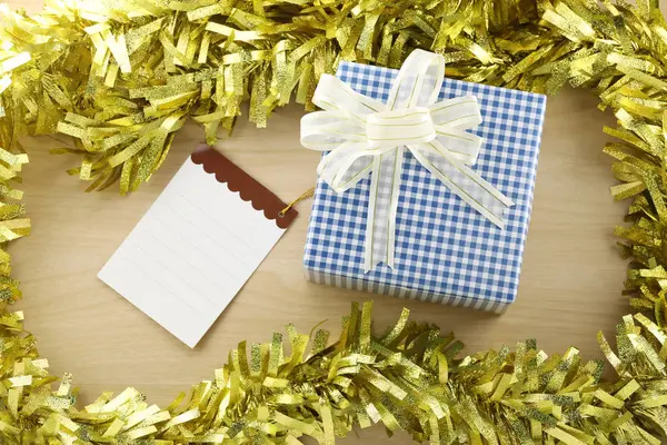 Posto scatola regalo blu vicino nota di carta vuota sul legno decorazione — Foto Stock