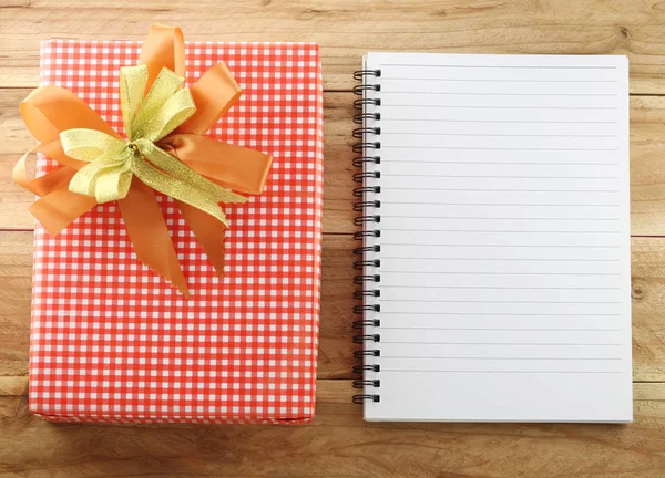 Scatola regalo rossa con libro bianco vuoto su sfondo di legno . — Foto Stock