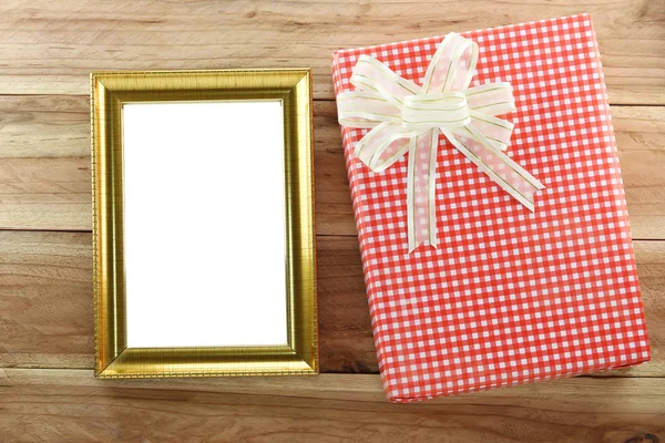 Caja de regalo roja con marco de madera vacío sobre fondo de madera . —  Fotos de Stock