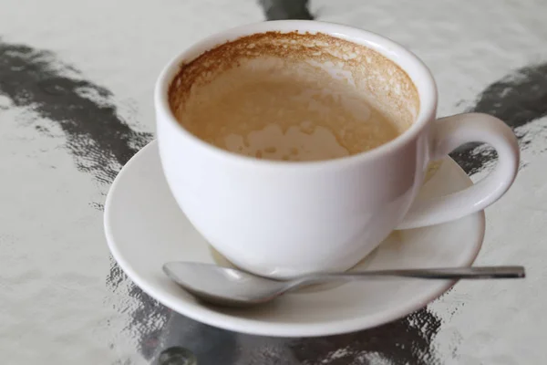 Taza de café blanco con manchas de café en la mesa . — Foto de Stock