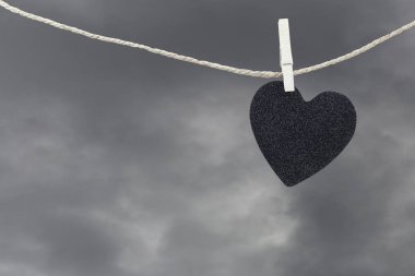 Yağmur bulutları ba kahverengi kenevir ipte asılı Black Heart kağıt