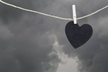 Yağmur bulutları ba kahverengi kenevir ipte asılı Black Heart kağıt