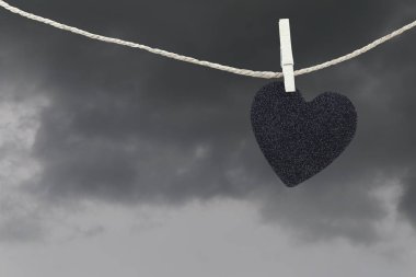 Yağmur bulutları ba kahverengi kenevir ipte asılı Black Heart kağıt