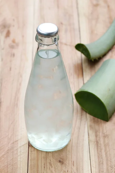 Jalea de Aloe Vera en las botellas de vidrio Cerca de la planta de Aloe Vera en woo — Foto de Stock