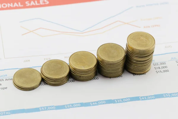 Gráfico de barras de monedas de oro en documentos comerciales de papel . —  Fotos de Stock