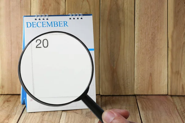 Zvětšovací sklo v rukou kalendáře můžete vypadat dvacáté den — Stock fotografie