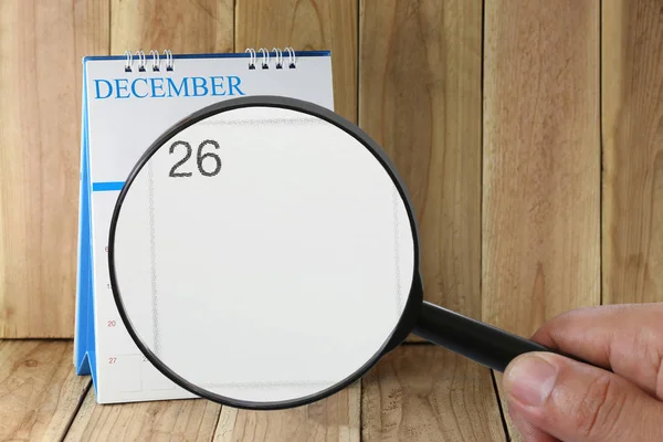Zvětšovací sklo v rukou kalendáře můžete vypadat dvacet šest den — Stock fotografie