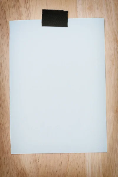 Μπλε χαρτί κενό σχετικά με το καφετί ξύλινο πάτωμα εκλεκτής ποιότητας χρώματος. — Φωτογραφία Αρχείου