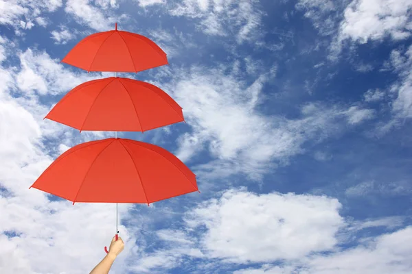 Parapluie rouge troisième couches dans la main et protection solaire plus de . — Photo