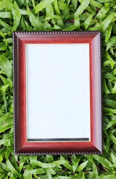 Brown picture frame on green lawn in top view.