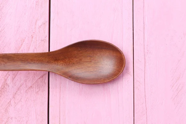 Wooden spoon on pink wood floors. — Stock Photo, Image