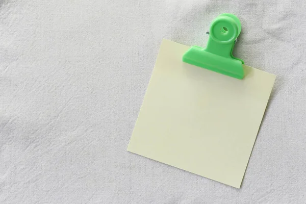 Amarillo de papel de nota colocado sobre fondo de tela blanca . — Foto de Stock