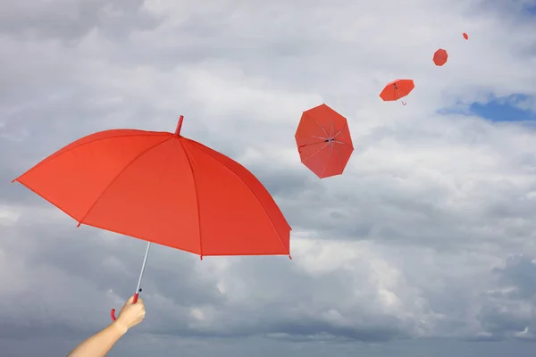 Parapluie rouge à la main et parapluie autre soufflé par le vent . — Photo