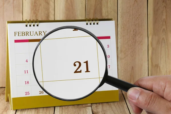 Zvětšovací sklo v rukou kalendáře můžete vypadat dvacátého jedna — Stock fotografie