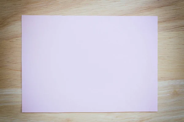 Papel rosa en blanco en el suelo de madera marrón de color vintage . — Foto de Stock