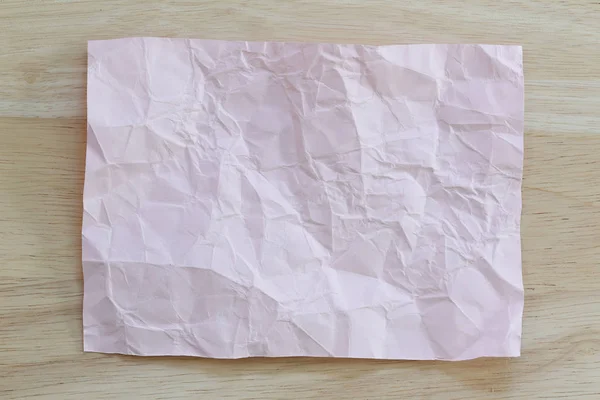 Roze Kladblok papier verfrommeld van lege en kopieer ruimte op houten ba — Stockfoto