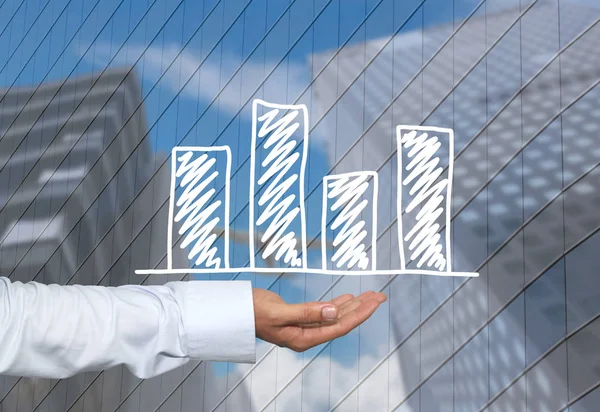 あなたのビジネスの人間手およびプレゼンテーションやコンセプトの高層ビルの背景に描かれた手のビジネスの棒グラフ — ストック写真
