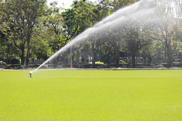 ゴルフ場のグリーンの芝生の水まきのスプリンクラーします。. — ストック写真