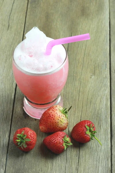 Succo di fragola in vetro sul pavimento del tavolo in legno . — Foto Stock