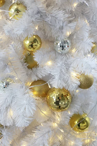 Goldene Kugeln hängen an einem weißen Weihnachtsbaum. — Stockfoto