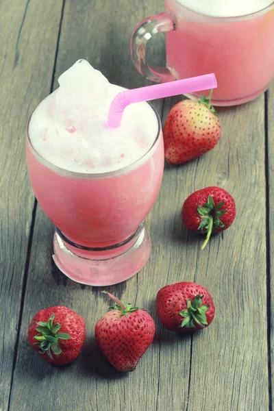 Jugo de fresa en vidrio sobre suelo de mesa de madera . — Foto de Stock