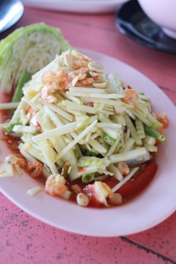 Beyaz tabak içinde ham mango salatası.