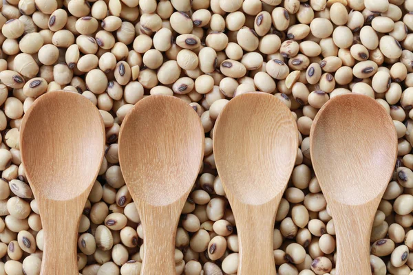 Empty wooden spoon on pile soybean. — Stock Photo, Image