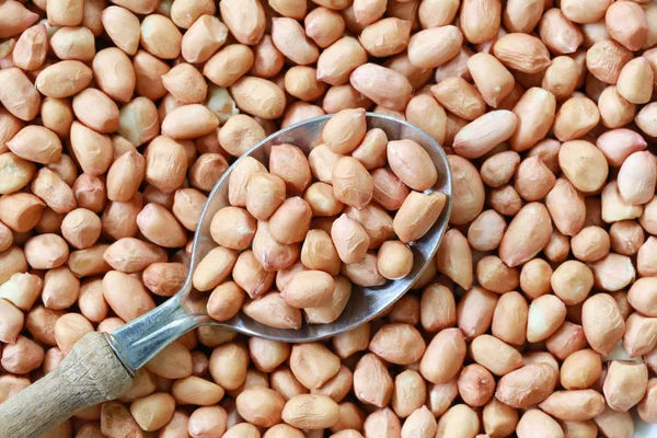 Peanut in Silver spoon on bean background. — Stock Photo, Image