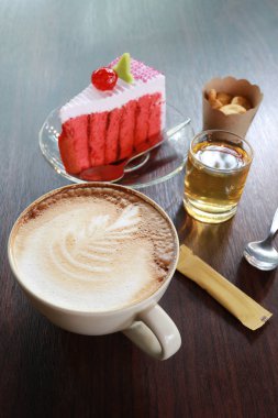 Kahve kupa ve kahverengi ahşap bir masa üzerinde kiraz kek.