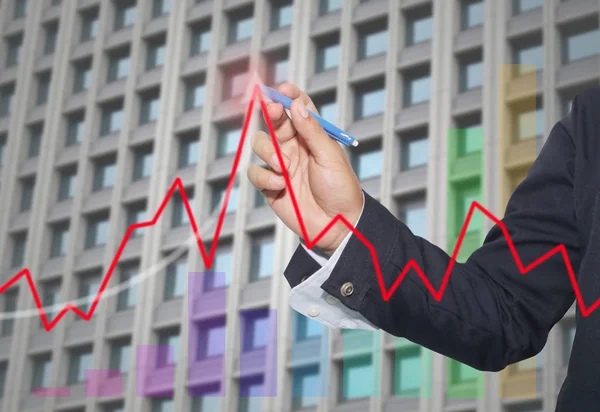 hand of businessman use red pen point to top line graph.