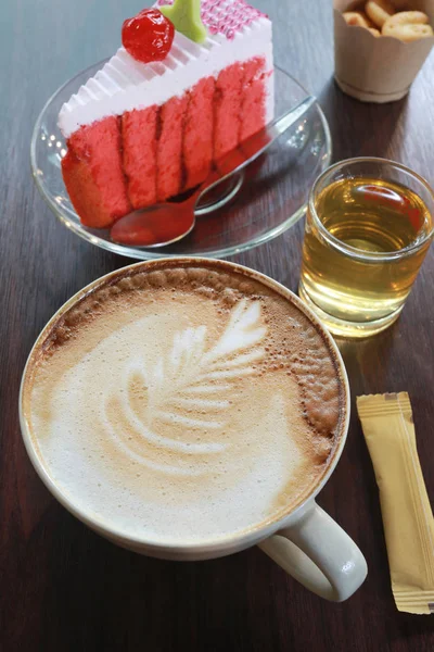 Tasse à café et gâteau cerise sur une table en bois marron . — Photo
