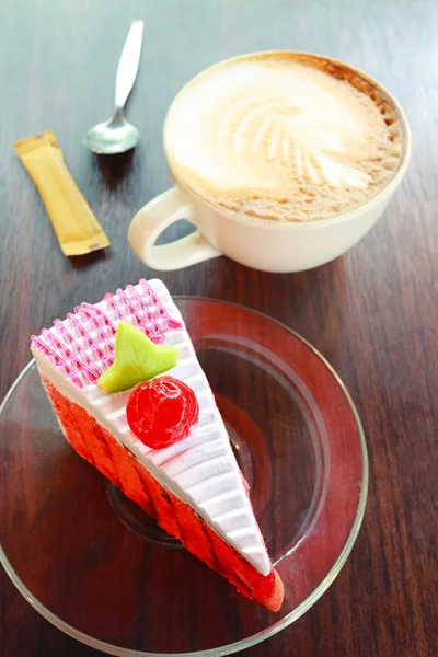 Caneca de café e bolo de cereja em uma mesa de madeira marrom . — Fotografia de Stock