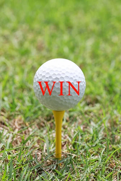 Červené písmeno Win na bílý golfový míček. — Stock fotografie
