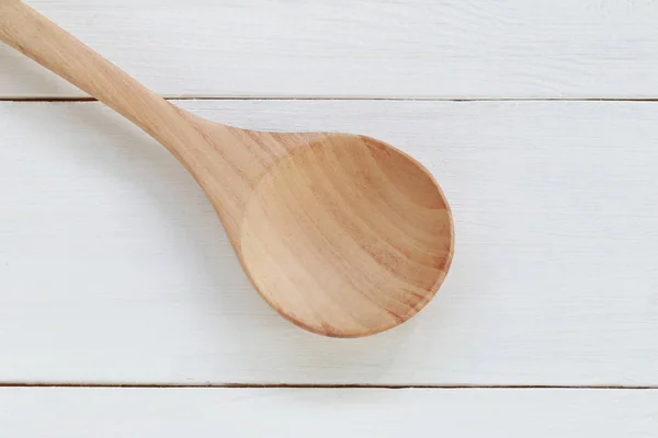 wooden spoon on white wood background.