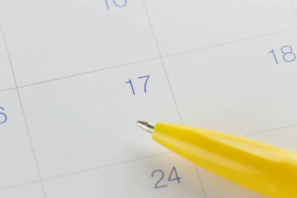 Penna gialla indica il numero 17 sullo sfondo del calendario . — Foto Stock