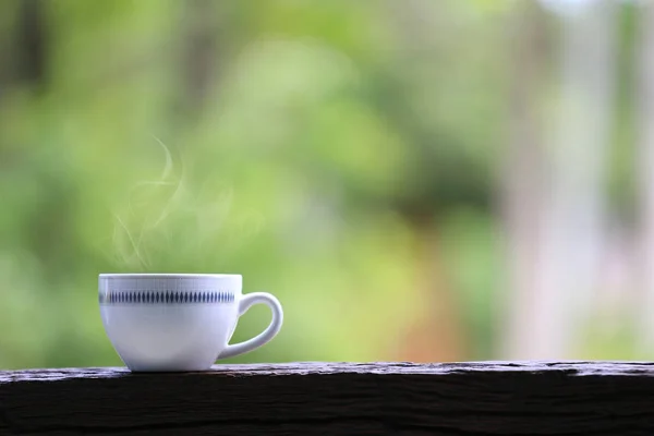 白色咖啡杯在木地板和绿色自然背景. — 图库照片