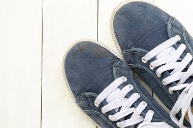 Beyaz ahşap zemin zemin üzerine eski spor ayakkabı.