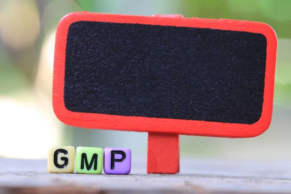 Пустой деревянный знак и пластиковый текстовый ящик GMP . — стоковое фото